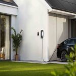 Anker V1 Smart EV Charger 7,4 kW Kabelversion an einer Hauswand montiert, Elektroauto wird geladen.