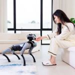 Magicdog Pro Roboterhund im Wohnzimmer bei der Interaktion mit einer Frau in entspannter Umgebung