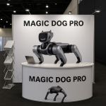 Magic Dog Pro robotic dog showcased at exhibition booth with promotional banner and laptop
