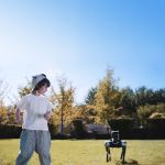 MagicDog Roboterhund beim Spielen mit Kind im Garten an einem sonnigen Tag